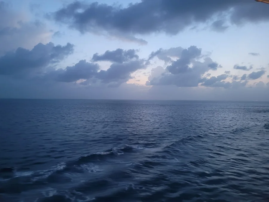 Ocean waves beneath a dramatic cloud-filled sky