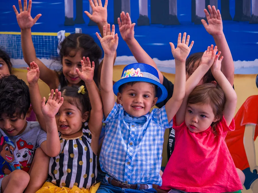 Children celebrating together with their hands raised