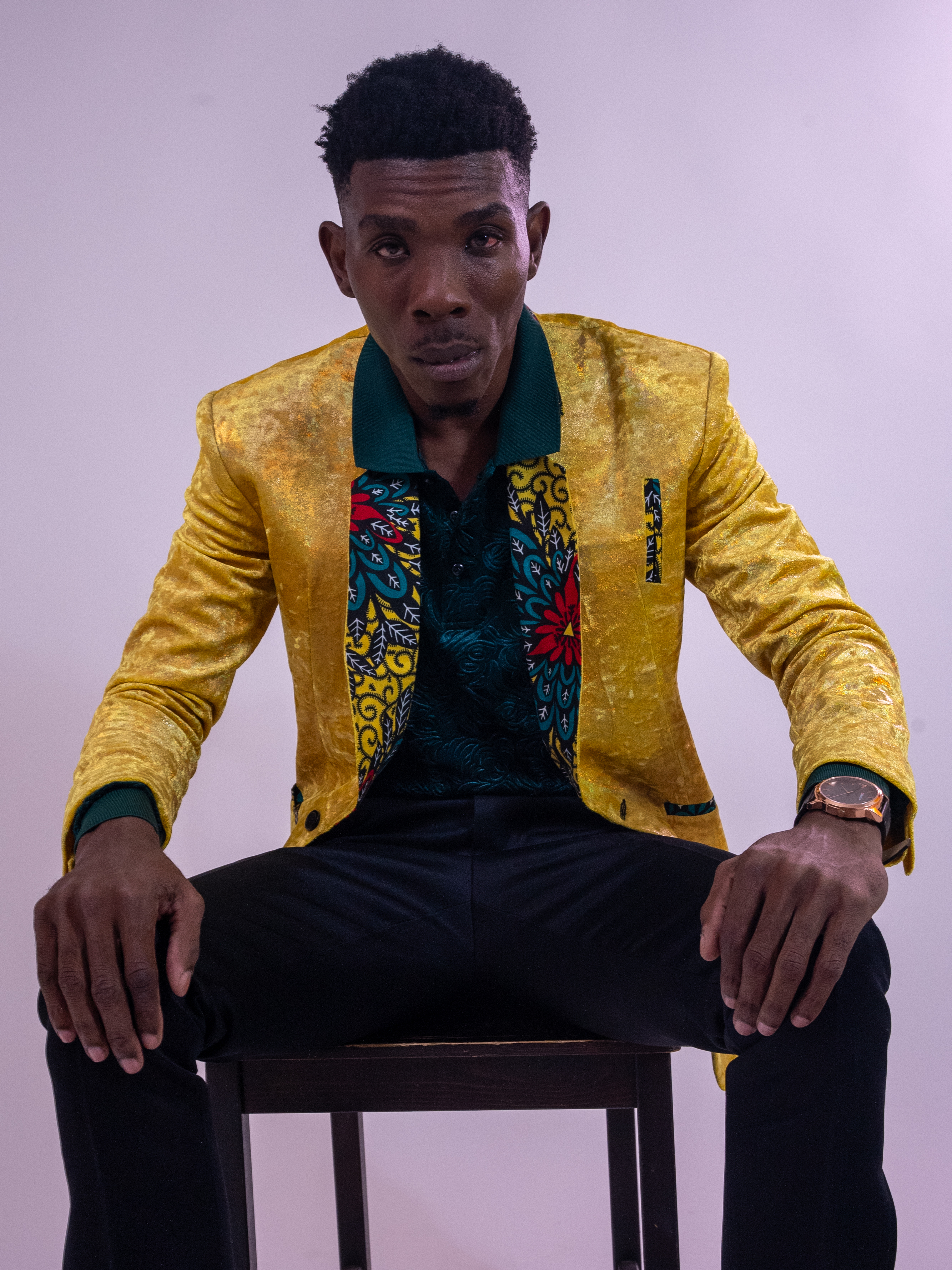 Seated portrait in a yellow jacket, leaning toward the camera