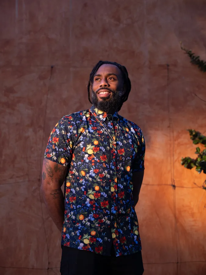 Portrait in a patterned shirt against a warm textured wall